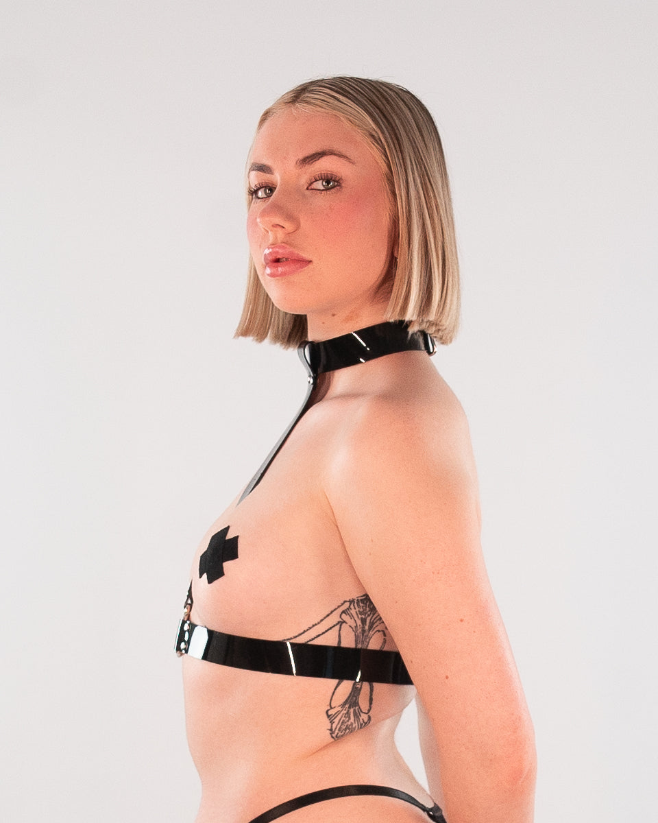 Side view of blonde a woman wearing a black Choker Harness