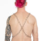 Tattooed man in a chain chest harness back view