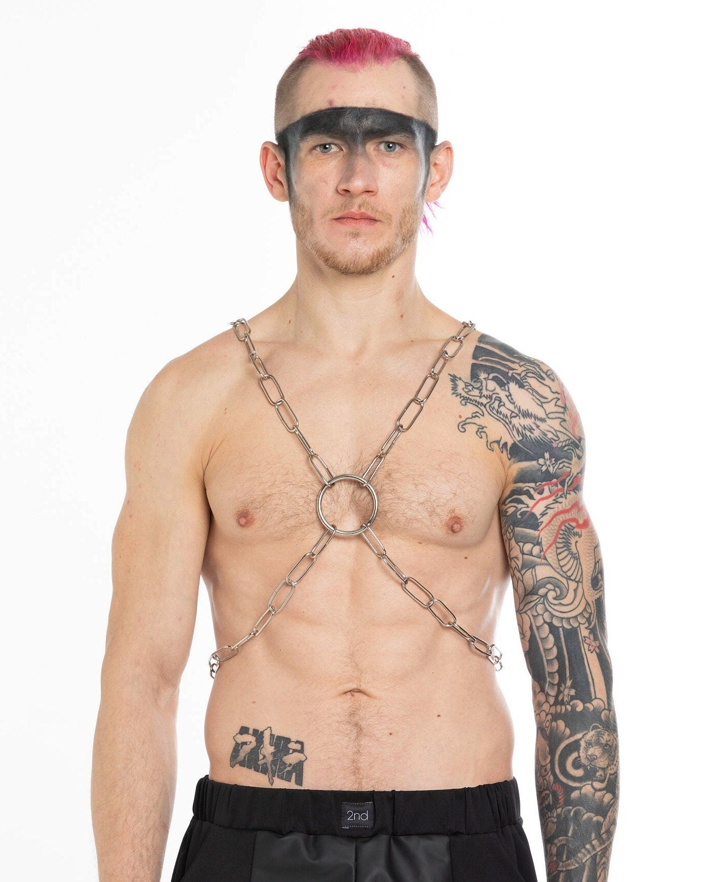 Tattooed man in a chain chest harness