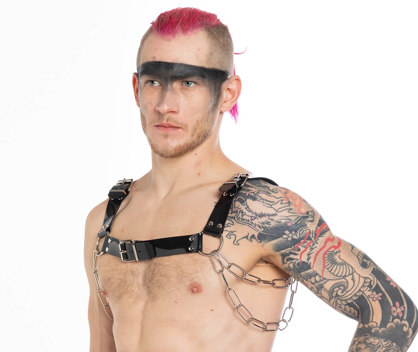 Tattooed Berlin raver with a PVC chest harness side view